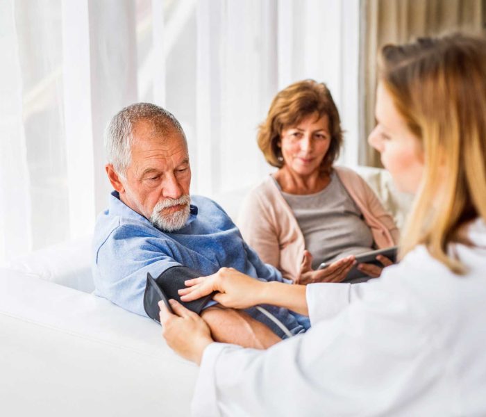 female-doctor-checking-blood-pressure-of-senior-ma-PDN3YZZ.jpg